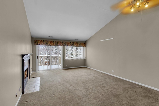 unfurnished living room with ceiling fan, light colored carpet, a fireplace, and vaulted ceiling