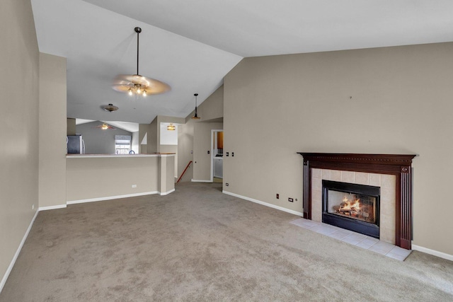 unfurnished living room with a fireplace, light colored carpet, vaulted ceiling, and ceiling fan