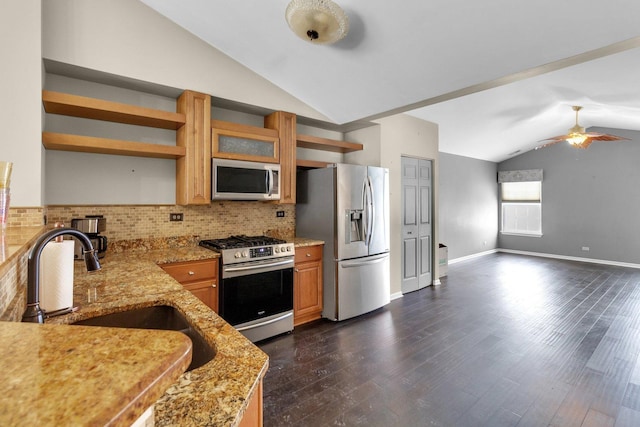 kitchen with light stone countertops, backsplash, stainless steel appliances, vaulted ceiling, and sink