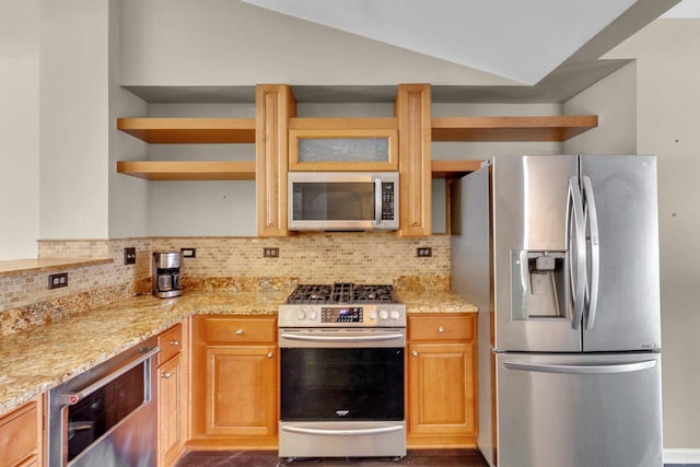 kitchen featuring backsplash, light stone counters, stainless steel appliances, and vaulted ceiling