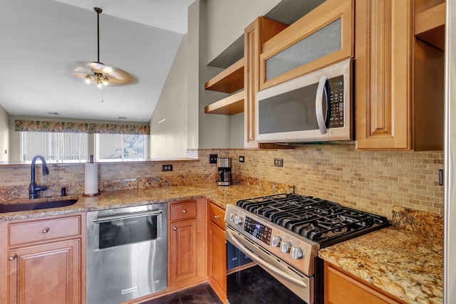 kitchen with light stone countertops, decorative backsplash, stainless steel appliances, sink, and lofted ceiling