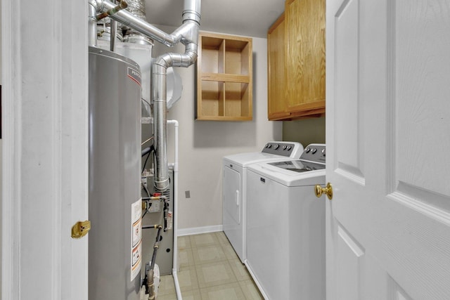 clothes washing area with washer and clothes dryer, cabinets, and gas water heater