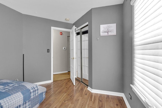 bedroom with light hardwood / wood-style floors and a closet