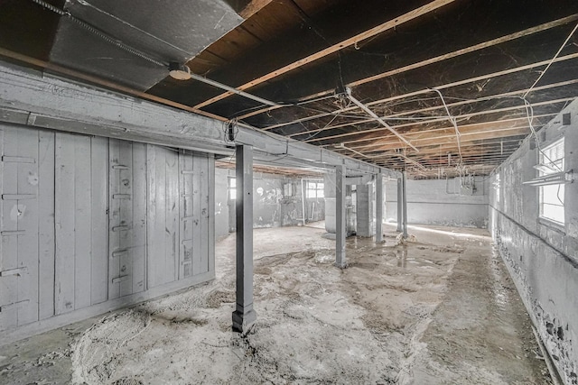 basement with wooden walls and heating unit