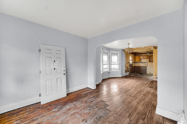 unfurnished living room featuring hardwood / wood-style flooring and a chandelier