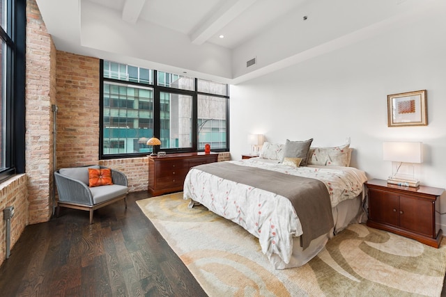 bedroom with hardwood / wood-style floors, beamed ceiling, and brick wall