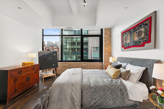 bedroom featuring brick wall and dark hardwood / wood-style floors