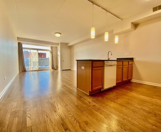 kitchen with hardwood / wood-style floors, white dishwasher, and hanging light fixtures