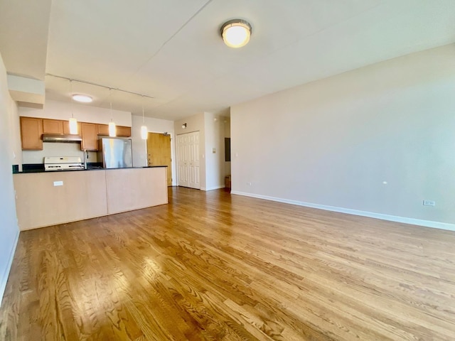 unfurnished living room featuring light hardwood / wood-style flooring and track lighting