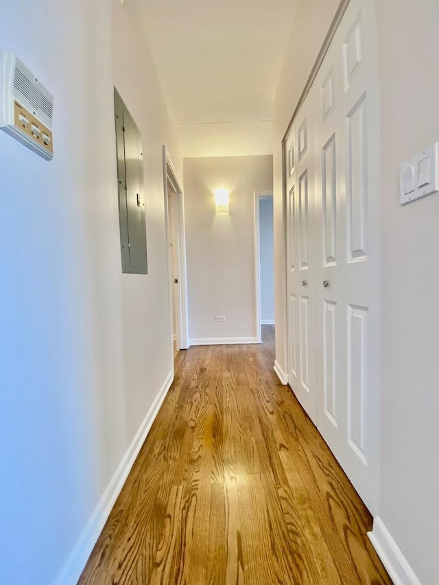 hall featuring electric panel and light hardwood / wood-style floors