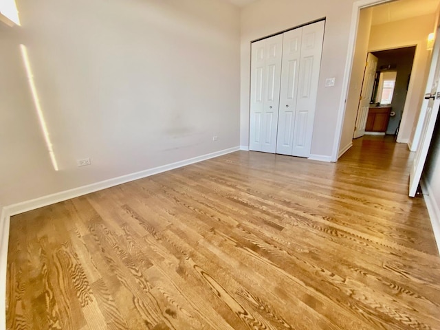 unfurnished bedroom with hardwood / wood-style floors and a closet