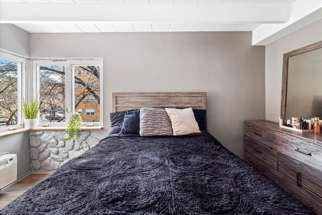 bedroom featuring beamed ceiling and wood-type flooring