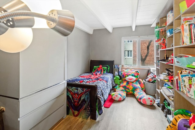 bedroom with beam ceiling and hardwood / wood-style floors