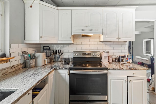 kitchen featuring light stone countertops, electric range, tasteful backsplash, and white cabinetry