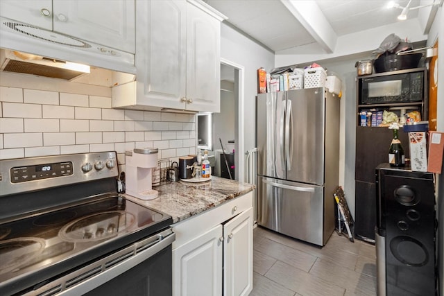 kitchen with white cabinets, light stone countertops, stainless steel appliances, and tasteful backsplash