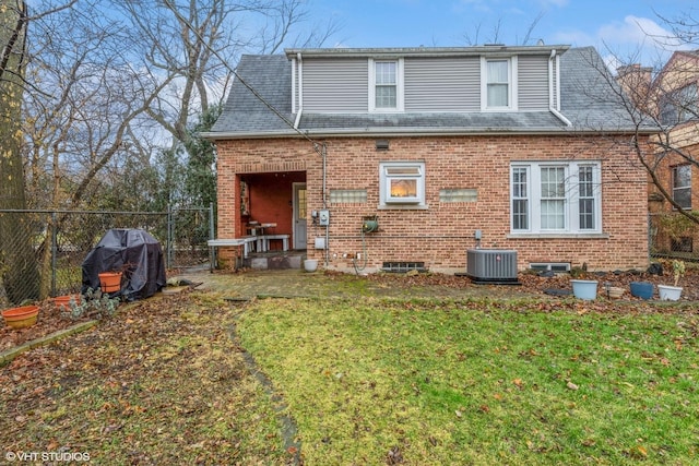 rear view of house with a yard and central AC