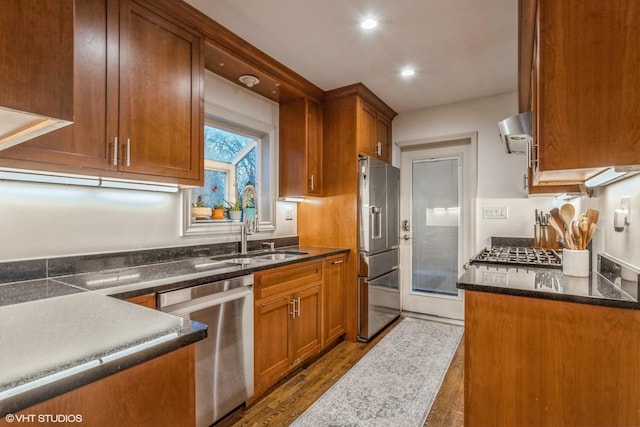 kitchen featuring dark hardwood / wood-style floors, sink, stainless steel appliances, and extractor fan