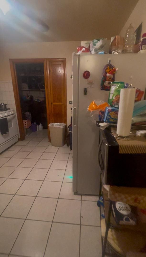 kitchen with white appliances and light tile patterned flooring