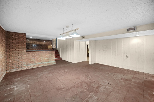 interior space featuring a textured ceiling and wooden walls