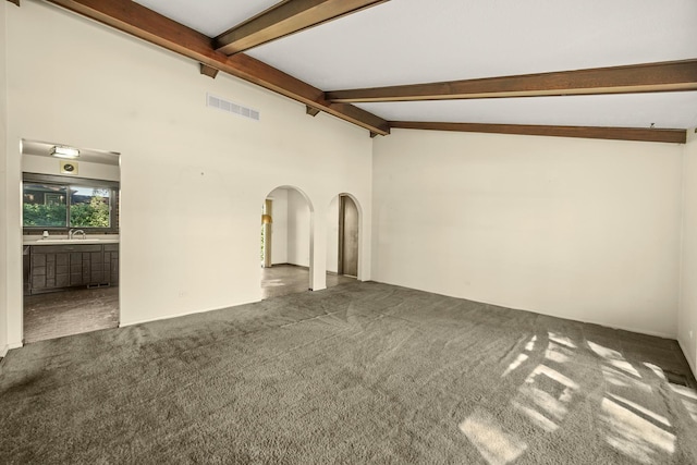 unfurnished living room featuring vaulted ceiling with beams and dark carpet