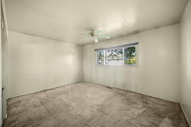 carpeted spare room featuring ceiling fan and a textured ceiling