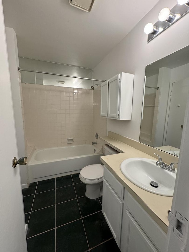 full bathroom featuring vanity, tiled shower / bath combo, tile patterned floors, and toilet