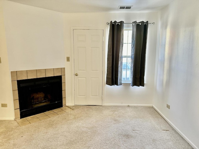 unfurnished living room with light carpet and a tile fireplace