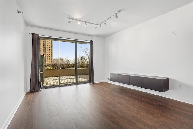 spare room with wood-type flooring and rail lighting