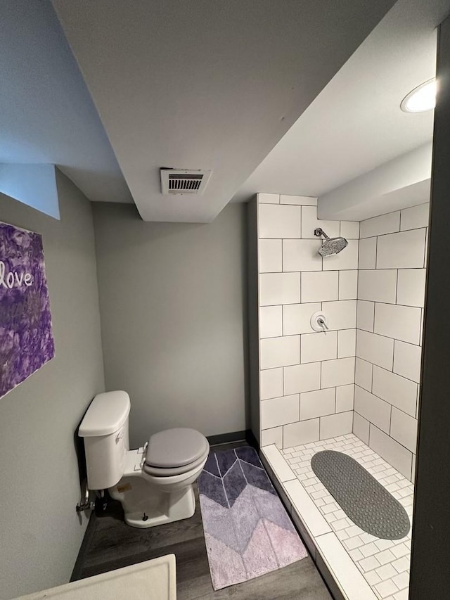 bathroom with toilet and tiled shower