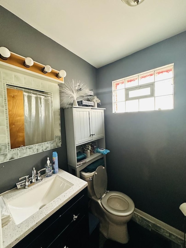 bathroom featuring vanity, a healthy amount of sunlight, and toilet