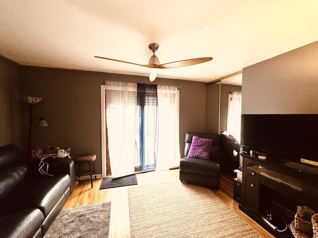 living room featuring light hardwood / wood-style flooring and ceiling fan