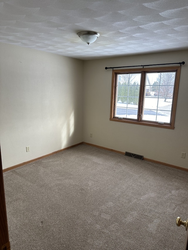 carpeted empty room with a textured ceiling