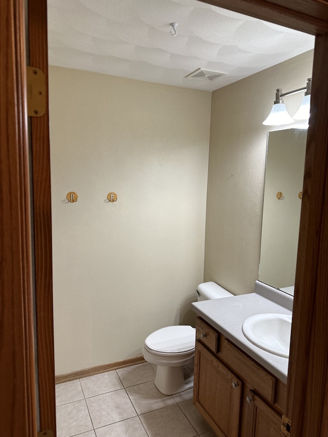 bathroom featuring tile patterned flooring, vanity, and toilet