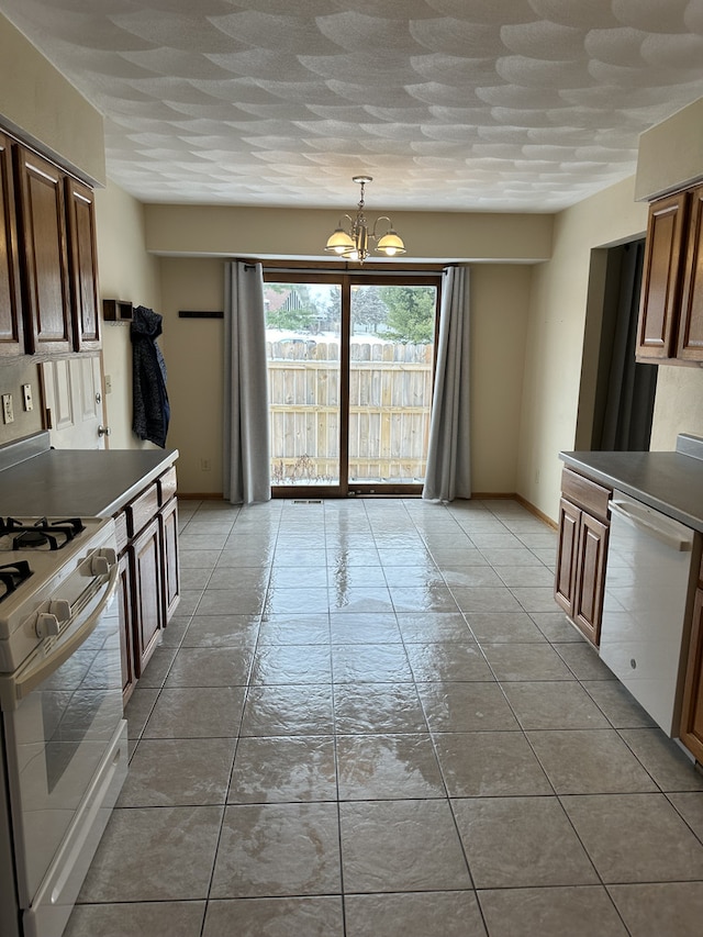 kitchen with a chandelier, white appliances, decorative light fixtures, and light tile patterned flooring