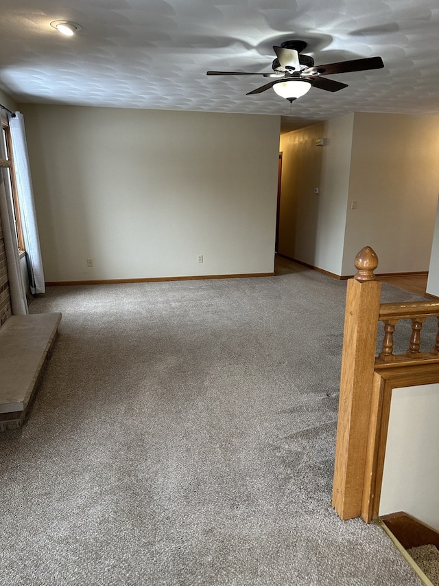 carpeted spare room with ceiling fan and a textured ceiling