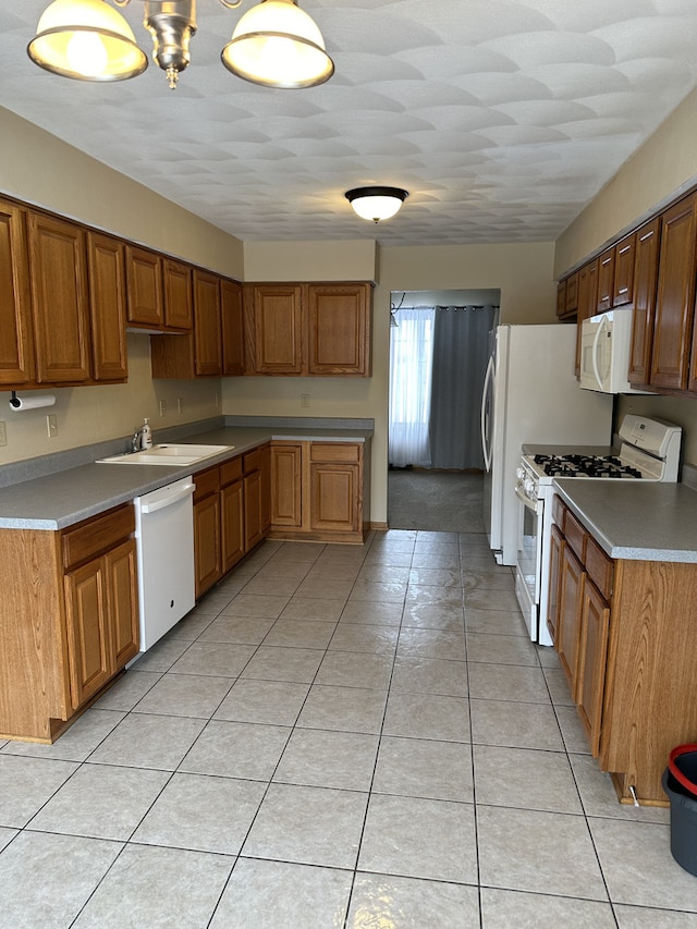 kitchen with sink, light tile patterned floors, and white appliances