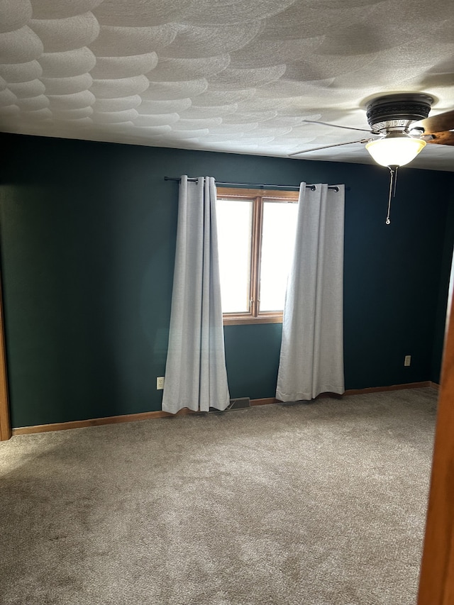 spare room with carpet floors and ceiling fan