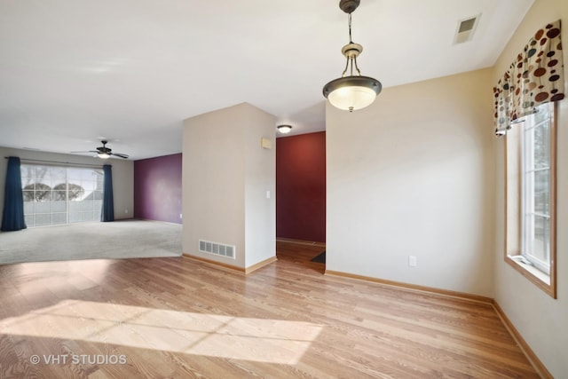 empty room with light hardwood / wood-style floors and ceiling fan