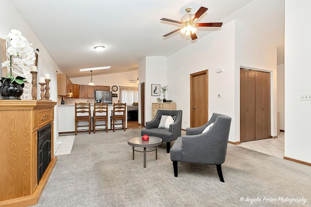 tiled living room with ceiling fan and vaulted ceiling