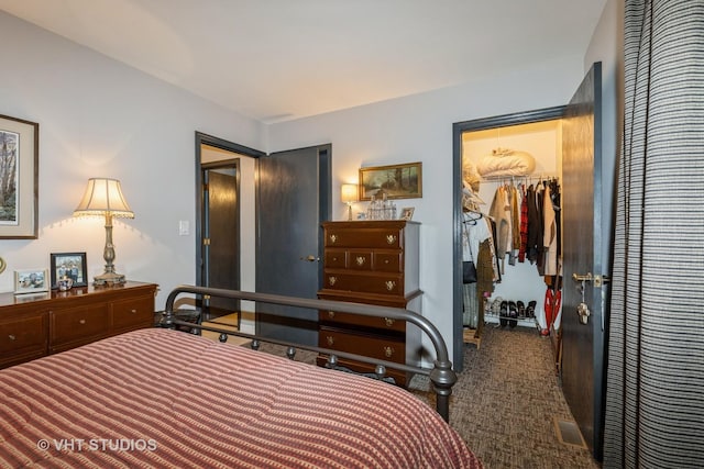 bedroom with a walk in closet, carpet floors, and a closet