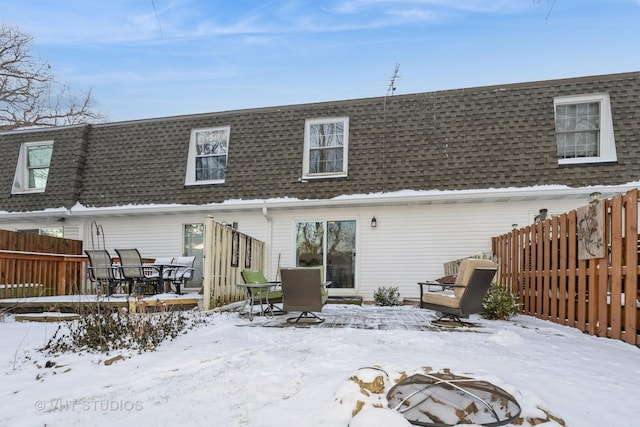 snow covered rear of property featuring an outdoor fire pit