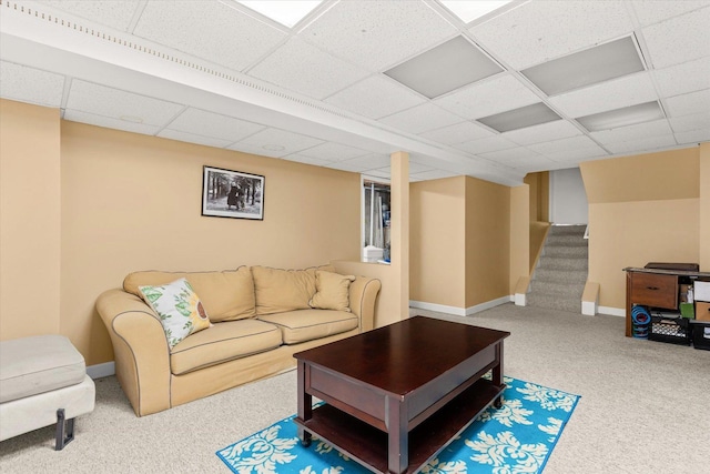 carpeted living room with a paneled ceiling