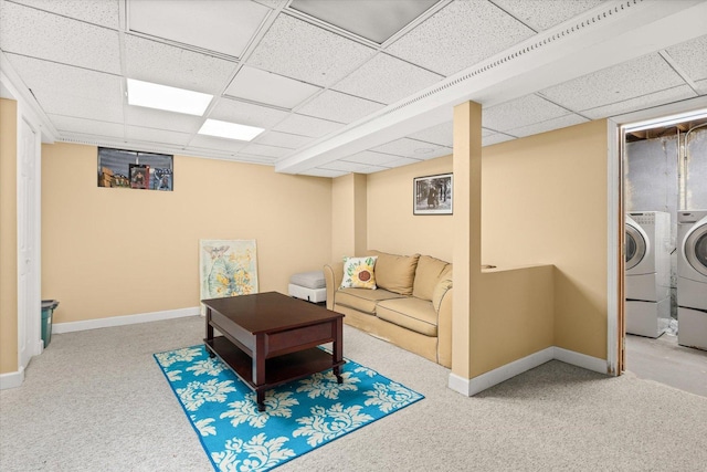 living room featuring a paneled ceiling, washing machine and dryer, and carpet floors