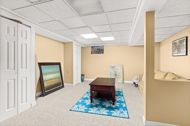 sitting room featuring carpet floors and a drop ceiling