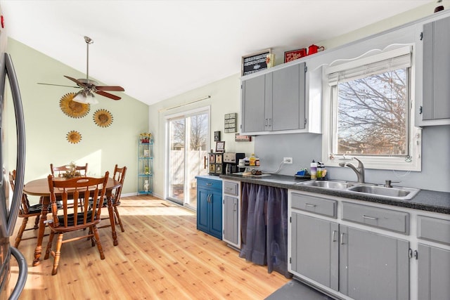 kitchen featuring light wood-type flooring, refrigerator, ceiling fan, sink, and lofted ceiling