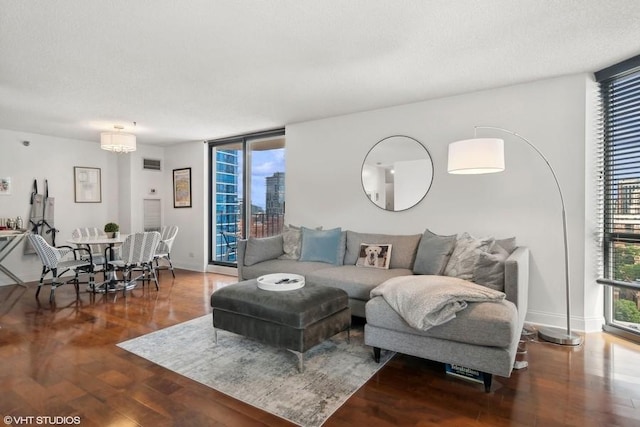 living room featuring floor to ceiling windows, a healthy amount of sunlight, a textured ceiling, and wood-type flooring