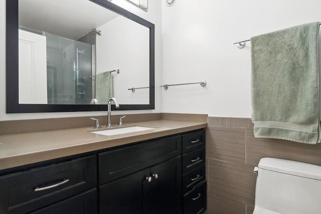 bathroom featuring vanity, an enclosed shower, tile walls, and toilet