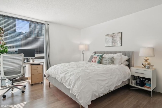 bedroom with dark hardwood / wood-style floors and a textured ceiling