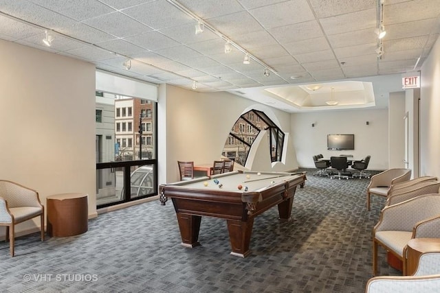 recreation room with dark colored carpet, a tray ceiling, track lighting, and pool table