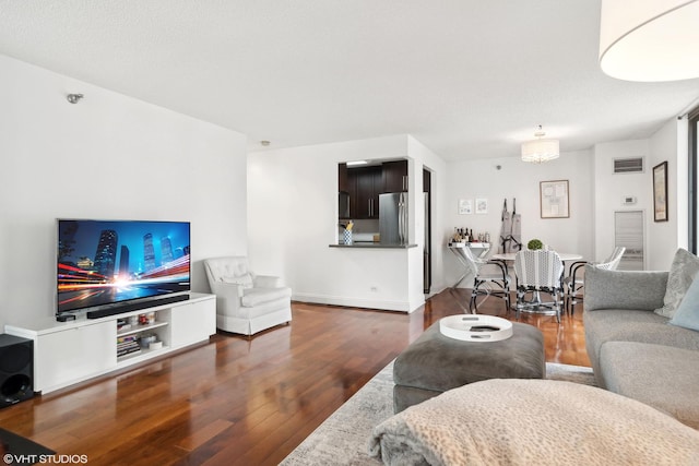 living room with a textured ceiling and dark hardwood / wood-style flooring